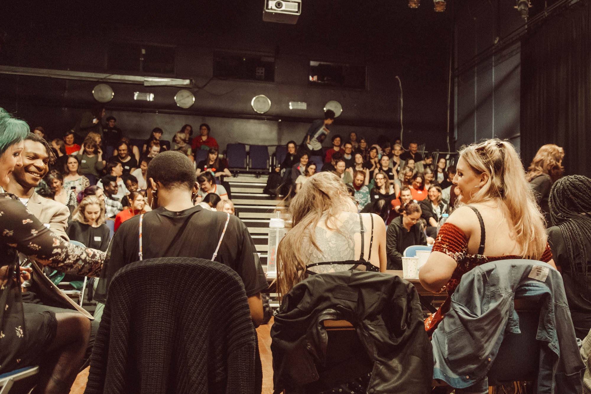 A large event / theatre like space filled with people.