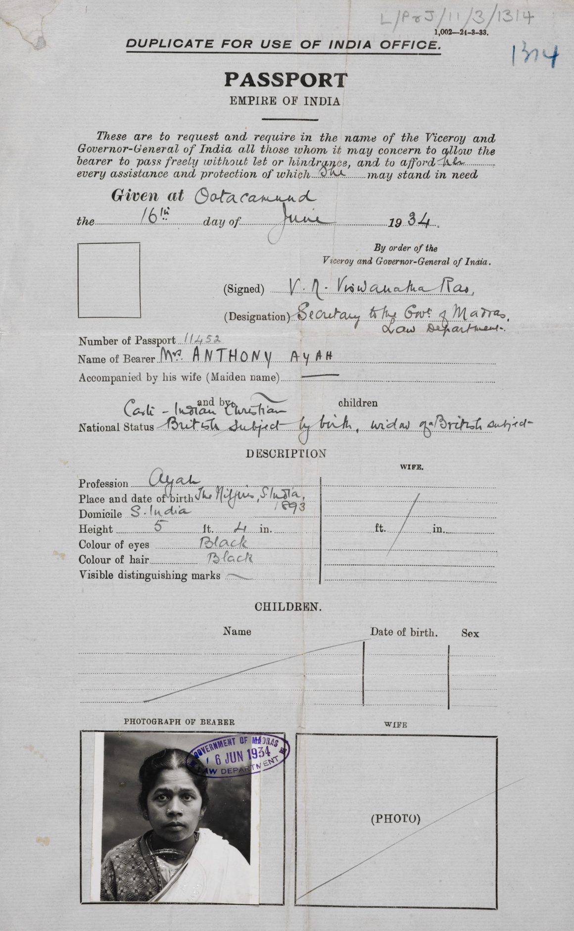 An archival image of a document that says 'Duplicate for use of India Office. PASSPORT'. The document has a black and white image of an indian woman looking into the camera.